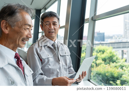 一名身穿工作服的男子正在現場操作電腦。 139080011