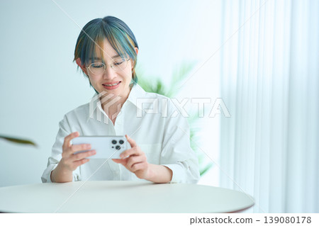 觀看智能手機的屏幕的婦女 觀看智能手機的屏幕的婦女 139080178