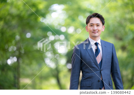一位推銷員走過綠樹成蔭的公園-上半身像是一位正在通勤或出差的商務人士。 一位推銷員走過綠樹成蔭的公園-上半身像是一位正在通勤或出差的商務人士。 139080442