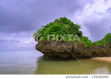 The tropical beach scenery of Ishigaki Island, with its rainy season sky and unique rock formations, is truly impressive. 139080899