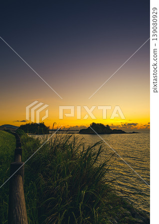 沖繩的日落美景,熱帶海濱長廊和寧靜的大海盡收眼底。 沖繩的日落美景,熱帶海濱長廊和寧靜的大海盡收眼底。 139080929