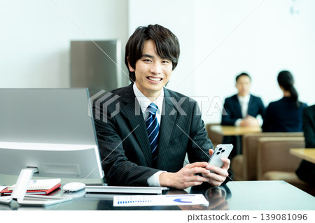 A businessman with a smartphone in the office A businessman with a smartphone in the office 139081096