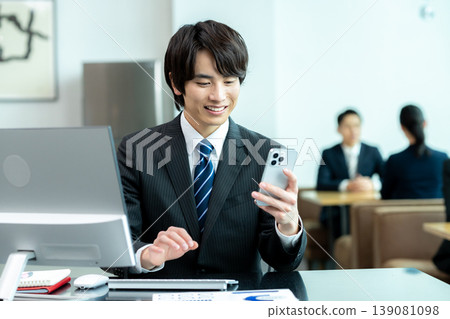 A businessman with a smartphone in the office A businessman with a smartphone in the office 139081098