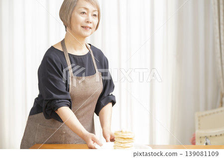 Senior woman eating pancakes in the dining room Senior woman eating pancakes in the dining room 139081109