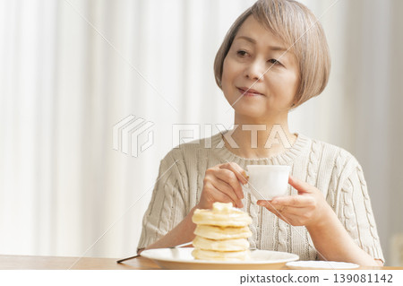 一位老婦人在餐廳吃煎餅 139081142