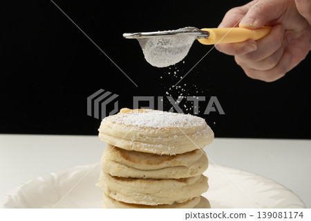 Place the cooked ricotta cheese pancakes on a plate. Place the cooked ricotta cheese pancakes on a plate. 139081174