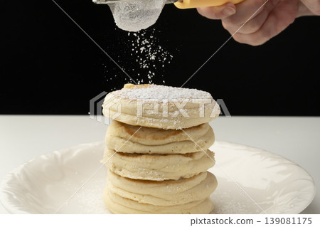 Place the cooked ricotta cheese pancakes on a plate. Place the cooked ricotta cheese pancakes on a plate. 139081175