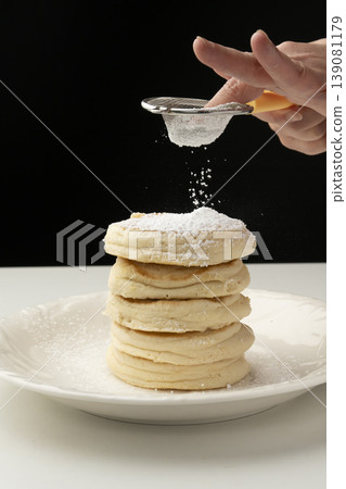 Place the cooked ricotta cheese pancakes on a plate. Place the cooked ricotta cheese pancakes on a plate. 139081179