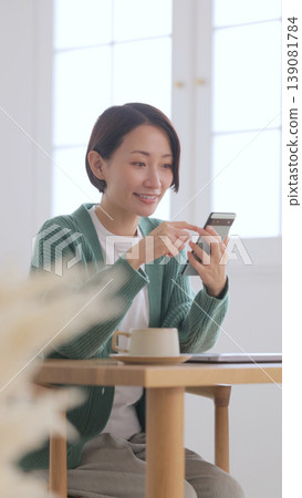 A woman watching a smartphone at a cafe A woman watching a smartphone at a cafe 139081784