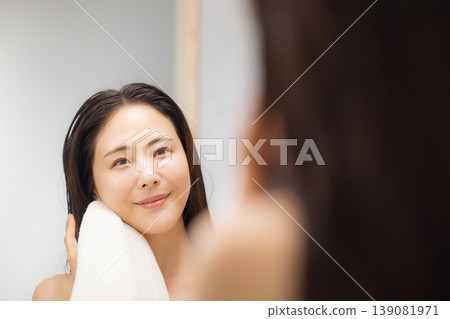 A woman doing hair care in the bathroom. A woman doing hair care in the bathroom. 139081971