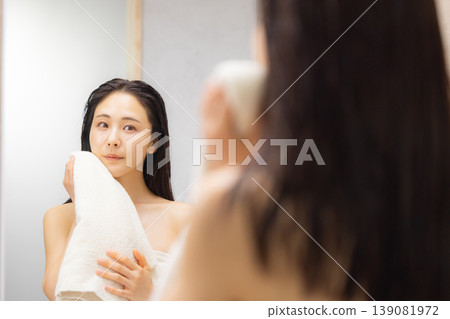 一位女士在浴室裡做頭髮護理。 139081972