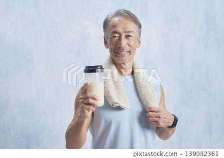 一位老年男子手持蛋白粉瓶訓練，目光看向鏡頭。 139082361