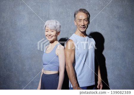 Portrait of senior man and woman exercising on black background Portrait of senior man and woman exercising on black background 139082389