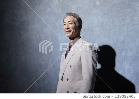 黑色背景上的一位身著西裝的老年男子的肖像 139082403