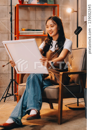 Female artist wears black hat posing near picture indoor the studio Female artist wears black hat posing near picture indoor the studio 139082845