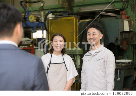 工廠裡的一個商業場景:一對夫婦正在接待訪客,一位信用社銷售員和一位來訪的銷售員正在開會。歡迎! 工廠裡的一個商業場景:一對夫婦正在接待訪客,一位信用社銷售員和一位來訪的銷售員正在開會。歡迎! 139082993