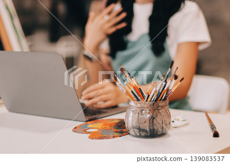 Female artist wears black hat posing near picture indoor the studio 139083537