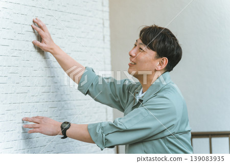 A middle-aged man inspecting the exterior walls. 139083935
