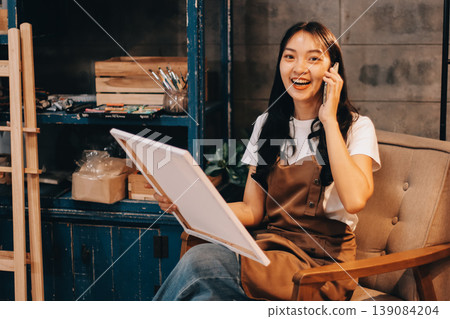 Female artist wears black hat posing near picture indoor the studio Female artist wears black hat posing near picture indoor the studio 139084204