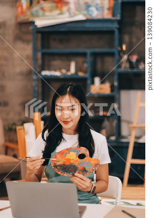 Female artist wears black hat posing near picture indoor the studio Female artist wears black hat posing near picture indoor the studio 139084230