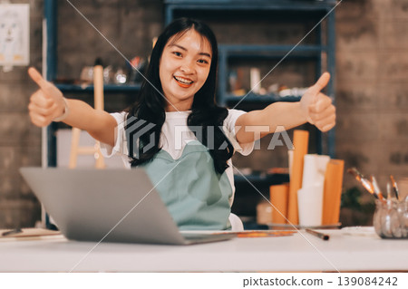 Female artist wears black hat posing near picture indoor the studio Female artist wears black hat posing near picture indoor the studio 139084242
