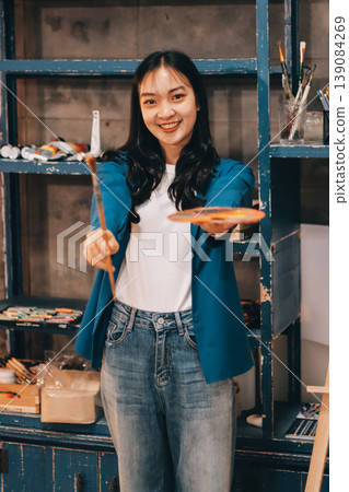Female artist wears black hat posing near picture indoor the studio Female artist wears black hat posing near picture indoor the studio 139084269