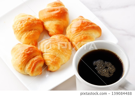 Croissants and coffee - A breakfast scene featuring freshly baked, crispy croissants and freshly brewed coffee. Croissants and coffee - A breakfast scene featuring freshly baked, crispy croissants and freshly brewed coffee. 139084488