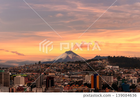 Stunning cityscape of Quito, Ecuador, under a golden sky at sunset. The imposing Cotopaxi Volcano rises on the horizon, emitting a plume of smoke Stunning cityscape of Quito, Ecuador, under a golden sky at sunset. The imposing Cotopaxi Volcano rises on the horizon, emitting a plume of smoke 139084636