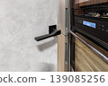 Modern Kitchen Detail with Black Door Handle and Built-in Appliances 139085256