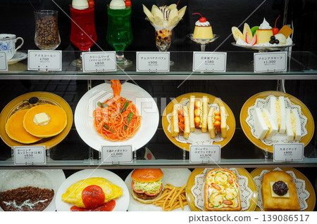 A variety of food samples displayed in front of restaurants, colorful Japanese Showa-era style coffee shops and Western-style menus. A variety of food samples displayed in front of restaurants, colorful Japanese Showa-era style coffee shops and Western-style menus. 139086517