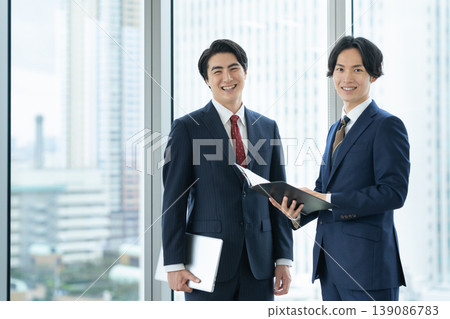 Businessmen holding a meeting in an office. Filming assistance provided by: Denpa Gakuen Educational Foundation, Tokyo Electronics College. Businessmen holding a meeting in an office. Filming assistance provided by: Denpa Gakuen Educational Foundation, Tokyo Electronics College. 139086783