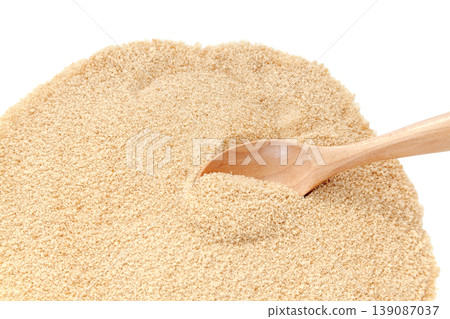 Scooping powdered brown sugar with a spoon [White background, cutout] 139087037