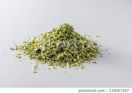 A photo of a large pile of dried parsley against a white background. A photo of a large pile of dried parsley against a white background. 139087307