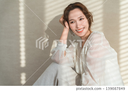 夕陽西下，窗邊站著一位女士（模特兒、時尚、光線、陰影） 139087849