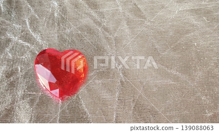 Red heart shaped gem placed on textured surface for decoration purposes Red heart shaped gem placed on textured surface for decoration purposes 139088063