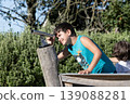 Children playing outdoors exploring wooden structure in green nature environment during sunny day activity 139088281