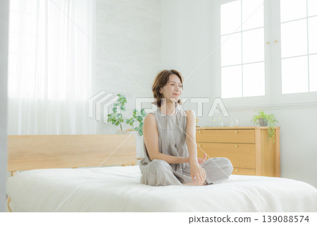 一個女人坐在床上 139088574
