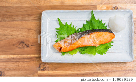 Salt-grilled salmon with grated daikon radish: A classic Japanese dish of grilled fish served on a long white plate. Salt-grilled salmon with grated daikon radish: A classic Japanese dish of grilled fish served on a long white plate. 139089159