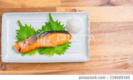 Salt-grilled salmon with grated daikon radish: A classic Japanese dish of grilled fish served on a long white plate. Salt-grilled salmon with grated daikon radish: A classic Japanese dish of grilled fish served on a long white plate. 139089160