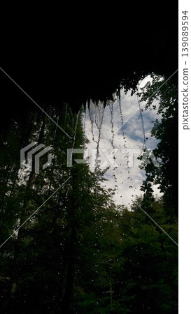 Phone photo of water falling from a cave entrance in a forest in Alsace. Scenic nature scene showing flowing water, woodland environment, and calm outdoor atmosphere. Phone photo of water falling from a cave entrance in a forest in Alsace. Scenic nature scene showing flowing water, woodland environment, and calm outdoor atmosphere. 139089594