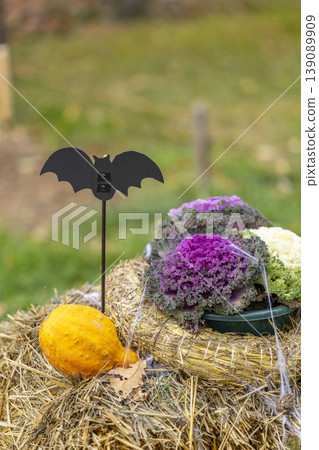 Halloween bat stake decorating hay bale with gourd 139089909