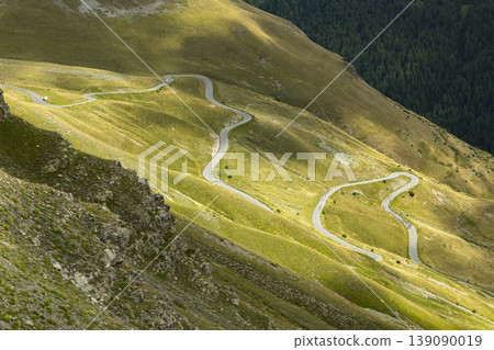 Winding mountain road traversing green slopes in Provence Alpes Cote d'Azur Winding mountain road traversing green slopes in Provence Alpes Cote d'Azur 139090019