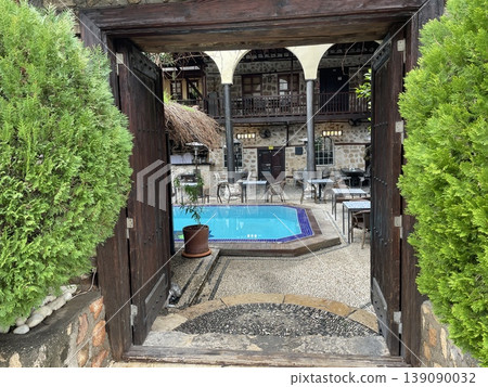 Courtyard pool view through rustic wooden gate in tropical setting, background Courtyard pool view through rustic wooden gate in tropical setting, background 139090032