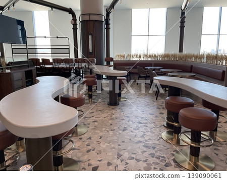Modern cafe interior with unique curved tables and ample natural light Modern cafe interior with unique curved tables and ample natural light 139090061