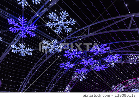 Illuminated snowflake light tunnel decorating winter holidays at night Illuminated snowflake light tunnel decorating winter holidays at night 139090112