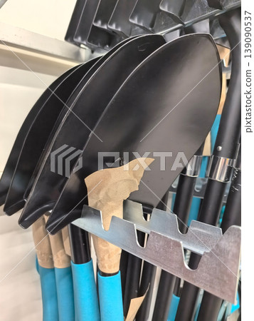 Black shovels displayed neatly on a tool rack in a well-organized workshop Black shovels displayed neatly on a tool rack in a well-organized workshop 139090537