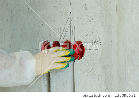 Electrician skillfully installing wiring in newly constructed wall 139090551