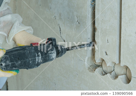 Electrician skillfully chasing electrical wiring during construction work 139090566