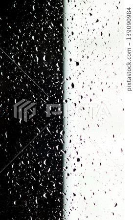 Minimalist texture of water drops on a glass surface. Rain on a clear window split into black and white sections creating a strong visual contrast 139090984