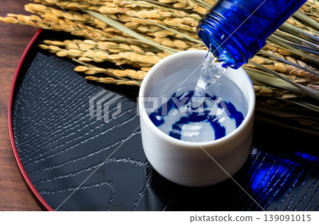 A scene of pouring sake, rice stalks, and a sake cup. A scene of pouring sake, rice stalks, and a sake cup. 139091015